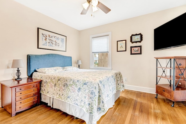 bedroom featuring a ceiling fan, baseboards, and wood finished floors