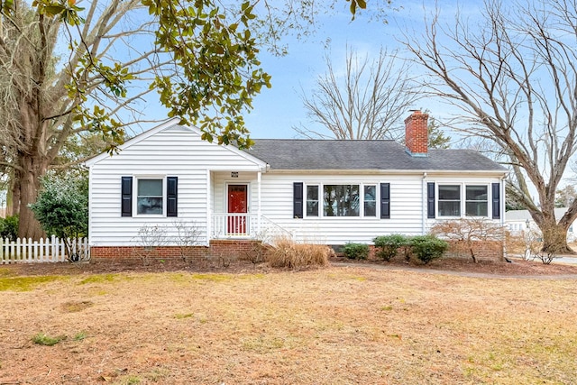 ranch-style house with a front lawn, a chimney, a shingled roof, and fence