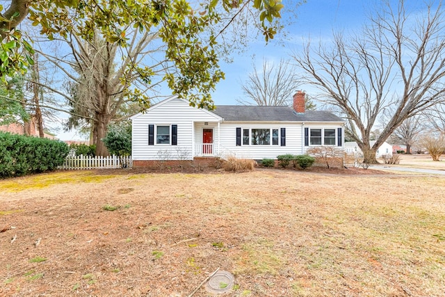 single story home with a front yard, fence, and a chimney