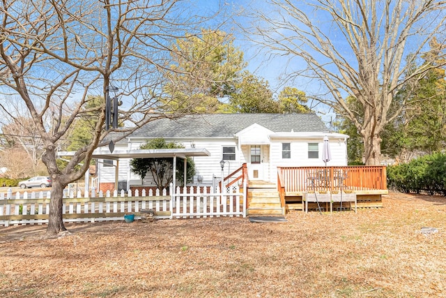 view of front of property with a fenced front yard, a shingled roof, and a wooden deck