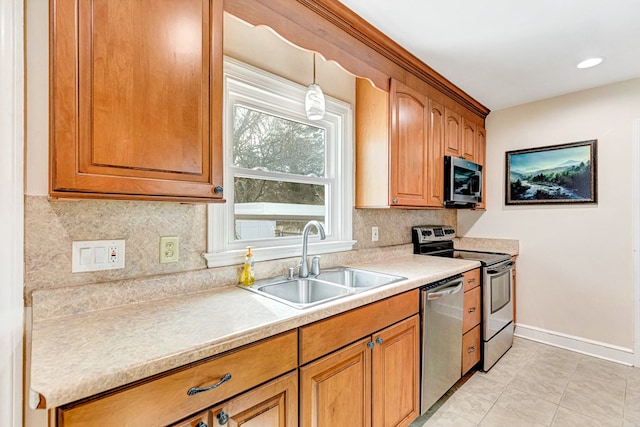 kitchen featuring a sink, light countertops, appliances with stainless steel finishes, backsplash, and decorative light fixtures