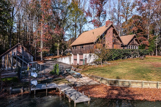 exterior space featuring a deck with water view and a yard