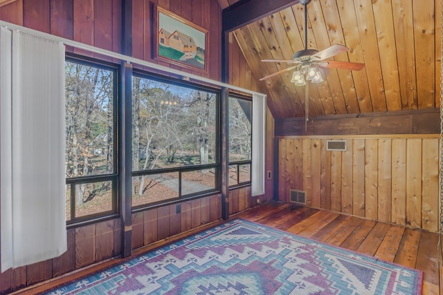 interior space with wooden ceiling, lofted ceiling with beams, hardwood / wood-style flooring, and wooden walls