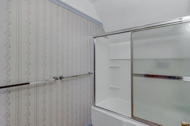 bathroom featuring lofted ceiling and bath / shower combo with glass door