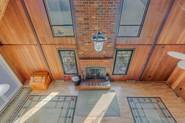 living room with hardwood / wood-style flooring, wood walls, and a fireplace