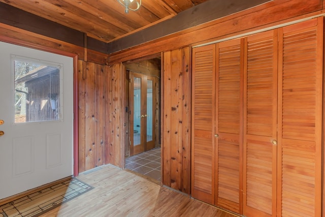 entryway with hardwood / wood-style flooring, wooden ceiling, and wood walls