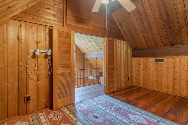 bonus room featuring ceiling fan, vaulted ceiling, wooden walls, wood ceiling, and hardwood / wood-style flooring