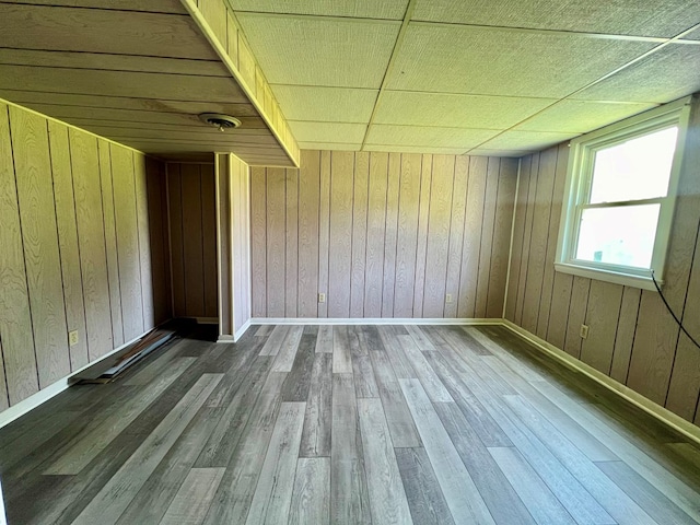 empty room with wooden walls and wood-type flooring