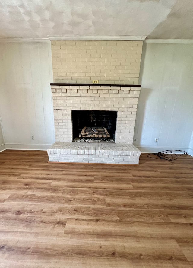 interior details featuring crown molding, a fireplace, a textured ceiling, and hardwood / wood-style flooring