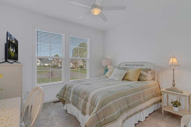 bedroom with multiple windows, light carpet, and ceiling fan