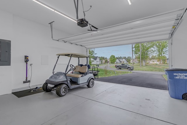 garage featuring a garage door opener, electric panel, and a lawn