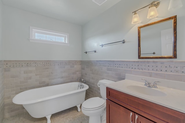 full bath with visible vents, wainscoting, toilet, a soaking tub, and tile walls