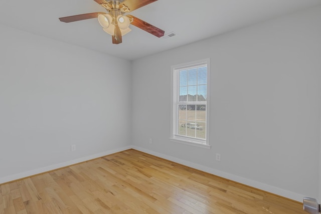 spare room featuring visible vents, ceiling fan, light wood-style flooring, and baseboards