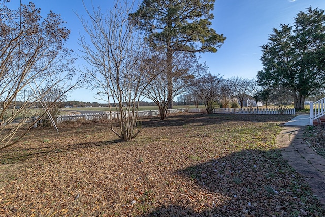 view of yard with a rural view and fence