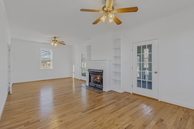 unfurnished living room with light hardwood / wood-style floors, ceiling fan, and built in features