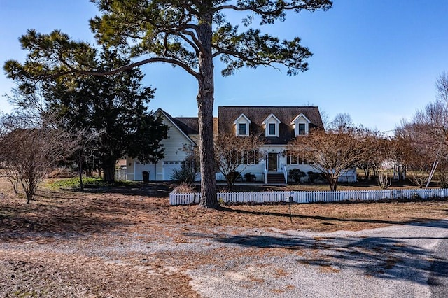 cape cod home with a fenced front yard