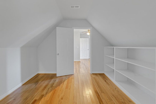 bonus room featuring lofted ceiling, visible vents, baseboards, and wood finished floors