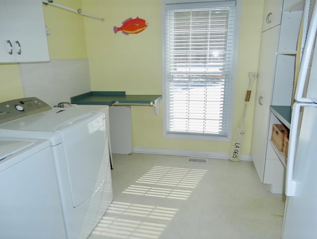 laundry room featuring visible vents, washer and clothes dryer, cabinet space, and baseboards