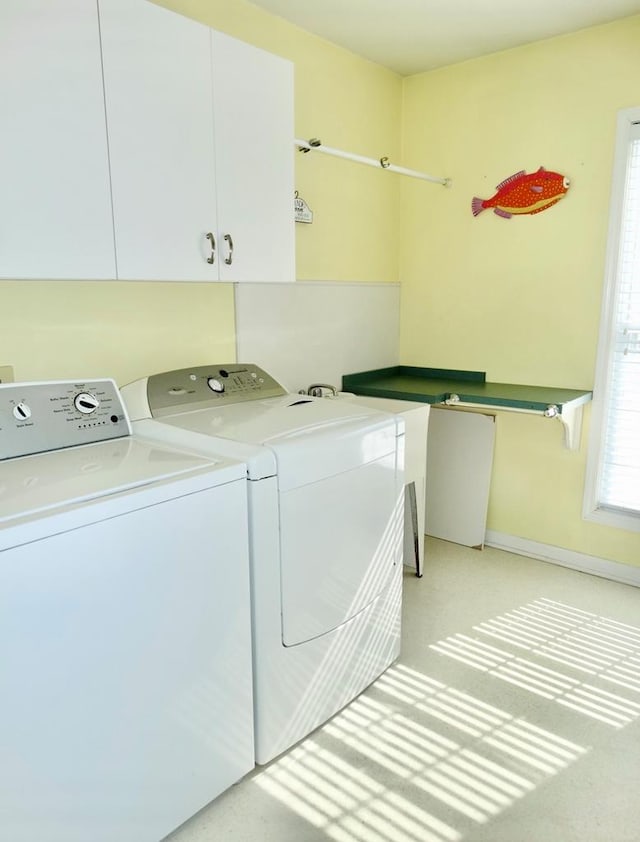 laundry area featuring cabinet space, washing machine and dryer, and baseboards