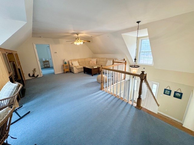 additional living space with lofted ceiling, ceiling fan, and carpet flooring