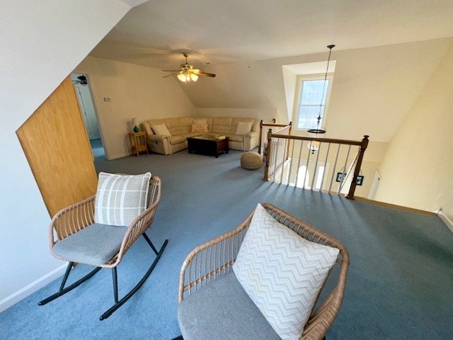 living area with ceiling fan, baseboards, carpet flooring, and an upstairs landing