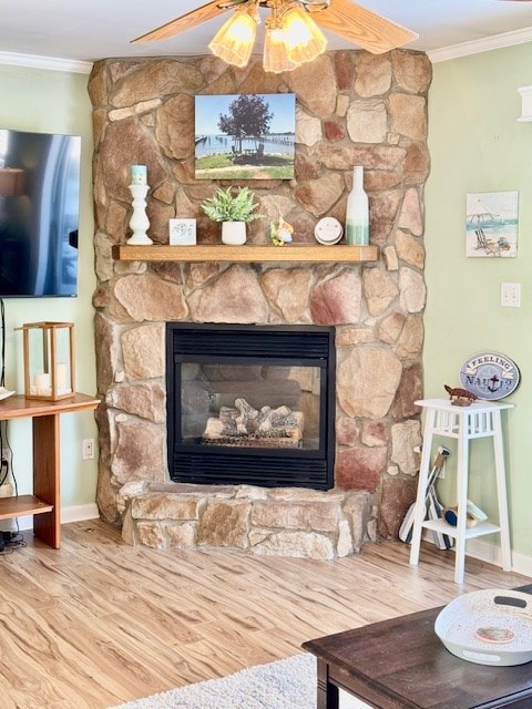 details with a fireplace, ornamental molding, ceiling fan, wood finished floors, and baseboards