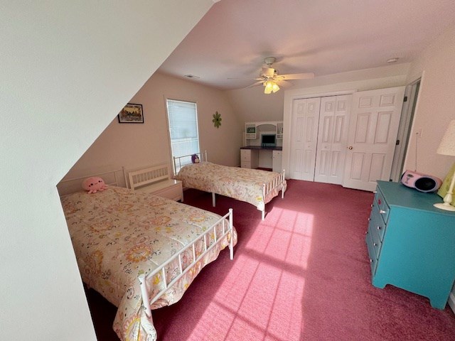 carpeted bedroom with a ceiling fan and a closet