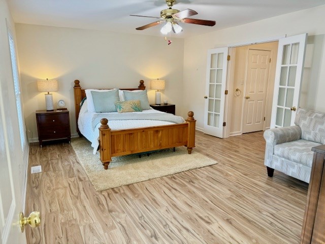 bedroom with light wood finished floors, ceiling fan, and baseboards