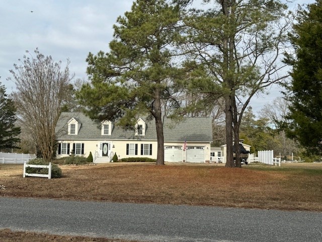 new england style home with a garage and fence