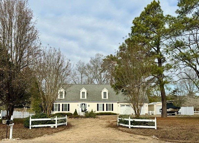 cape cod house featuring a fenced front yard