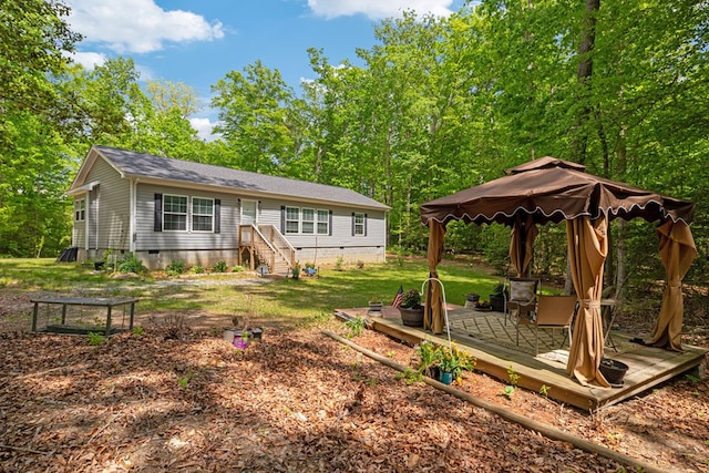 exterior space featuring roof with shingles, a gazebo, a wooden deck, crawl space, and a yard