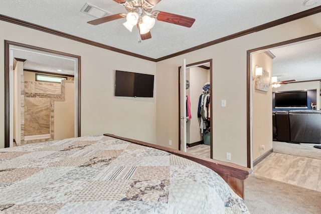carpeted bedroom featuring visible vents, a textured ceiling, a spacious closet, and a closet