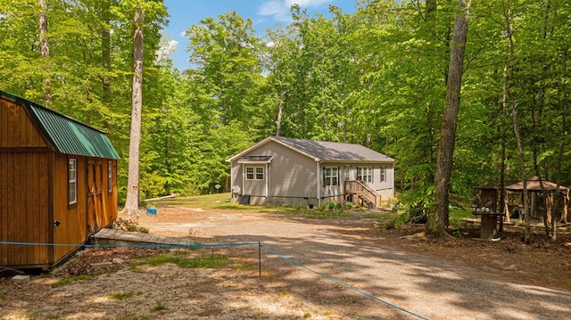 exterior space with a gazebo and a view of trees