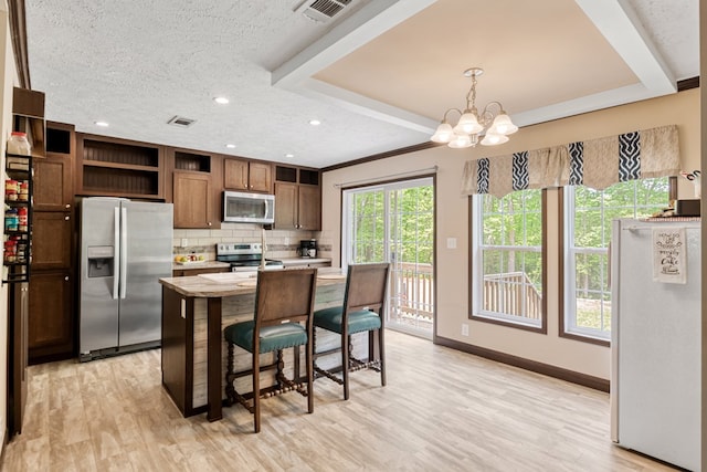 kitchen featuring visible vents, open shelves, light countertops, a chandelier, and stainless steel appliances