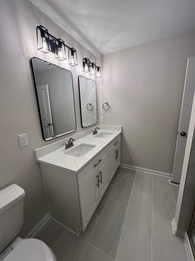 605 Shorewood Dr, Colonial Beach, VA 22443 - full bath featuring toilet, double vanity, marble look tiles, and baseboards