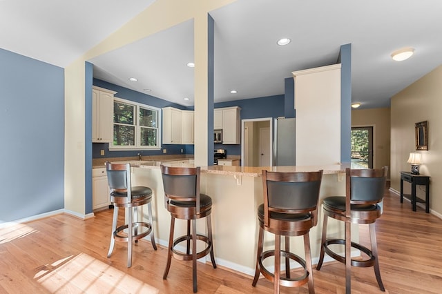 341 Pine Reach Dr, Kilmarnock, VA 22482 - kitchen featuring a wealth of natural light, light wood-style floors, appliances with stainless steel finishes, and a peninsula