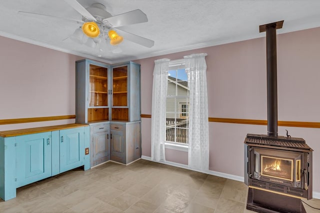15 Surry St, Ophelia, VA 22473 - interior space featuring a wood stove, a ceiling fan, ornamental molding, and baseboards