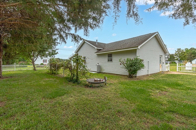 15 Surry St, Ophelia, VA 22473 - view of home's exterior featuring an outdoor fire pit and a shingled roof