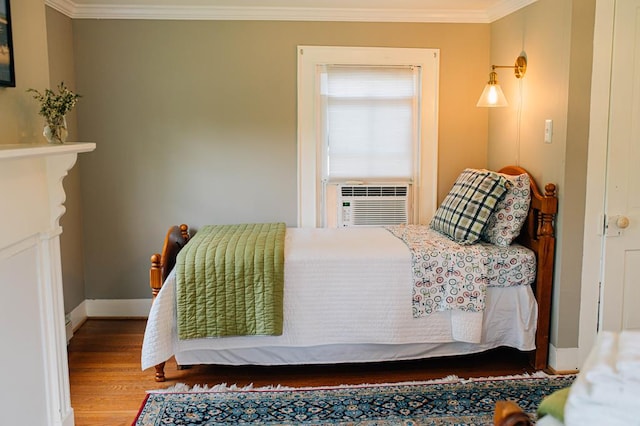 bedroom with cooling unit, crown molding, wood finished floors, and baseboards
