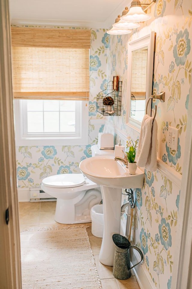 bathroom with tile patterned flooring, toilet, baseboard heating, wallpapered walls, and baseboards