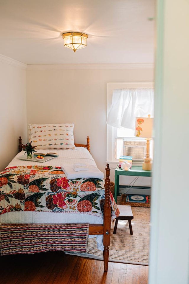 bedroom featuring wood-type flooring, cooling unit, and ornamental molding