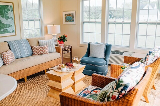 living area with baseboards and an AC wall unit