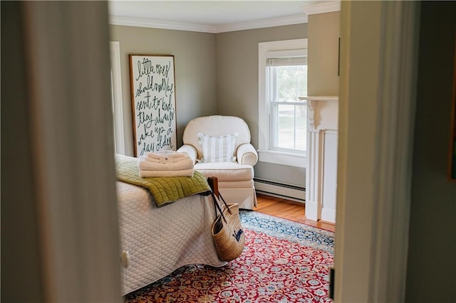 living area featuring baseboard heating, wood finished floors, and ornamental molding