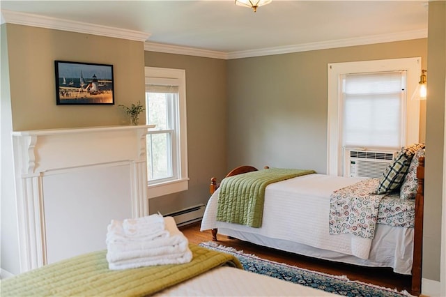 bedroom featuring a baseboard heating unit, ornamental molding, and wood finished floors