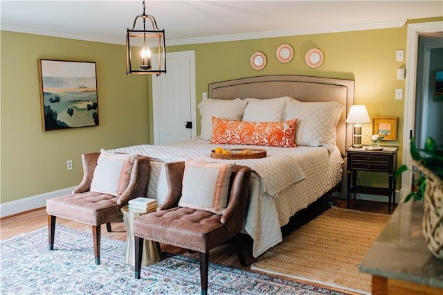 bedroom featuring baseboards, ornamental molding, and wood finished floors