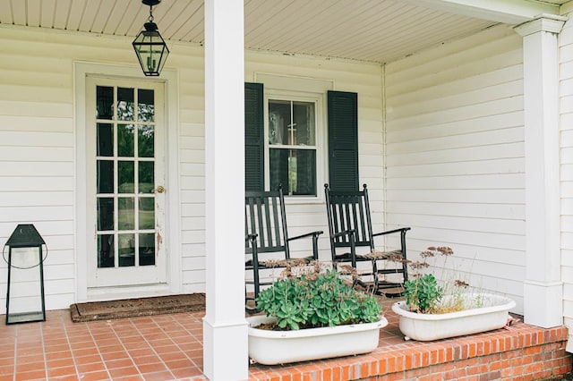 view of exterior entry featuring covered porch