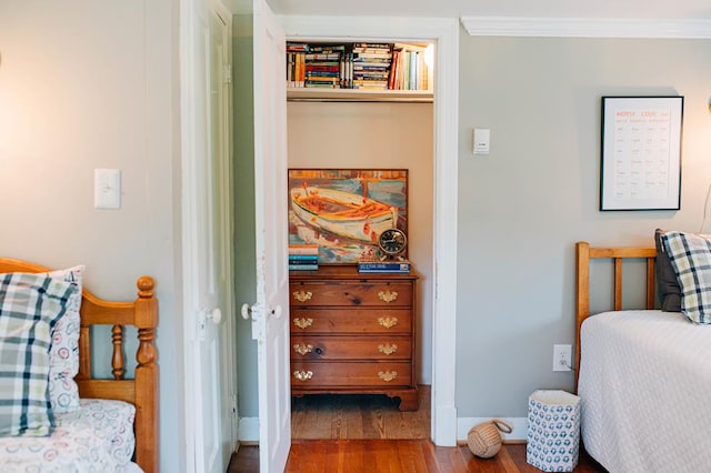 bedroom featuring crown molding, wood finished floors, and baseboards