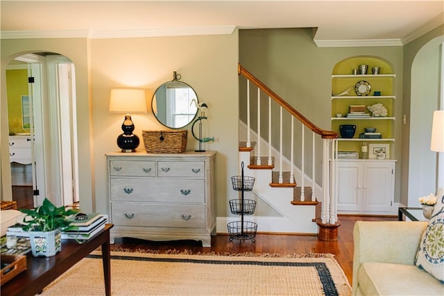 interior space with built in features, stairway, crown molding, arched walkways, and wood finished floors