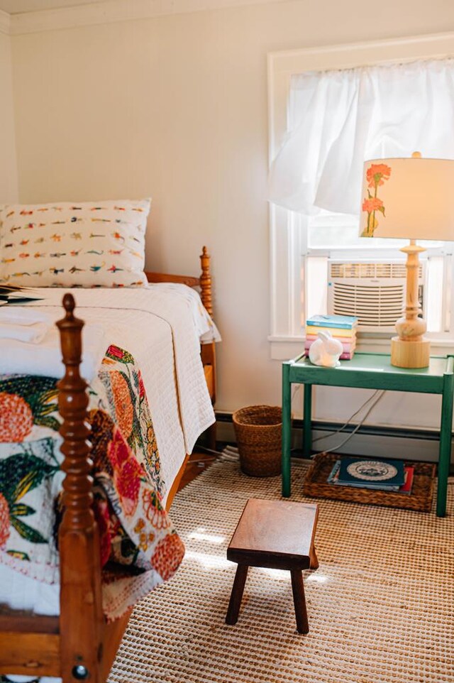 bedroom with cooling unit, a baseboard radiator, a baseboard heating unit, and ornamental molding