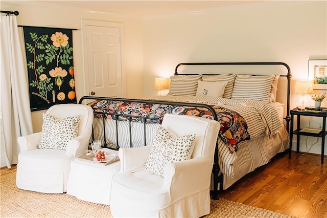 bedroom featuring crown molding and wood finished floors